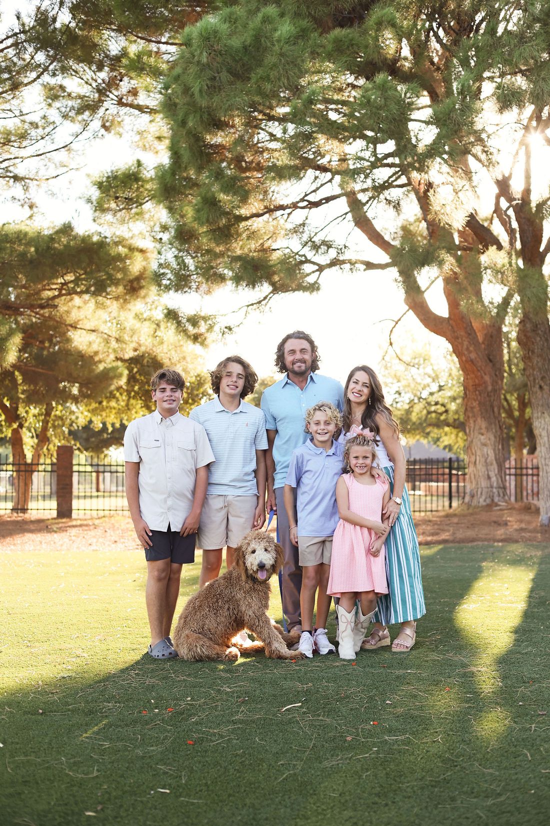 The Gotcher family standing together on the lawn with their dog